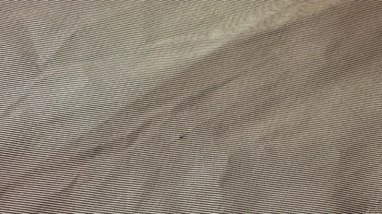 Close-up of a PTFE liner surface used in heim joints, showing smooth texture for low-friction operation