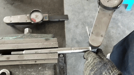 Turning the torque gauge handle to one side while the dial shows the breakaway torque